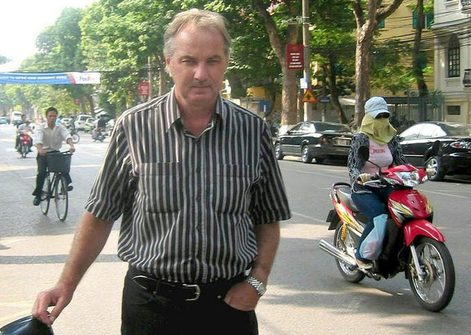 HLV Riedl rảo bước trên đường phố Việt Nam, nơi ông có ba giai đoạn làm HLV đội tuyển.