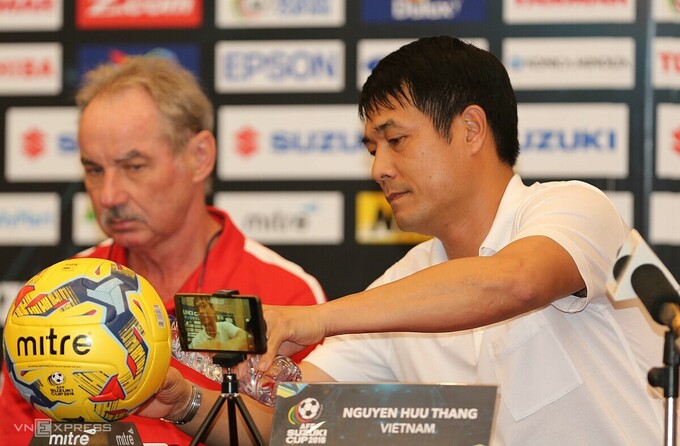 HLV Hữu Thắng rót nước mời thầy cũ Alfred Riedl trong cuộc họp báo ở AFF Cup 2016. Lúc này, ông dẫn dắt đội tuyển Indonesia. Ảnh: Đức Đồng.